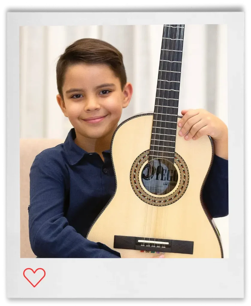 Retrato do músico e violeiro mirim JP Violeiro sorrindo para a câmera enquanto apresenta sua viola caipira em detalhe.
